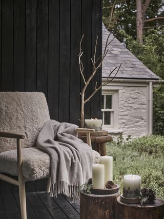 White company cozy sitting area with candles and pine cones
