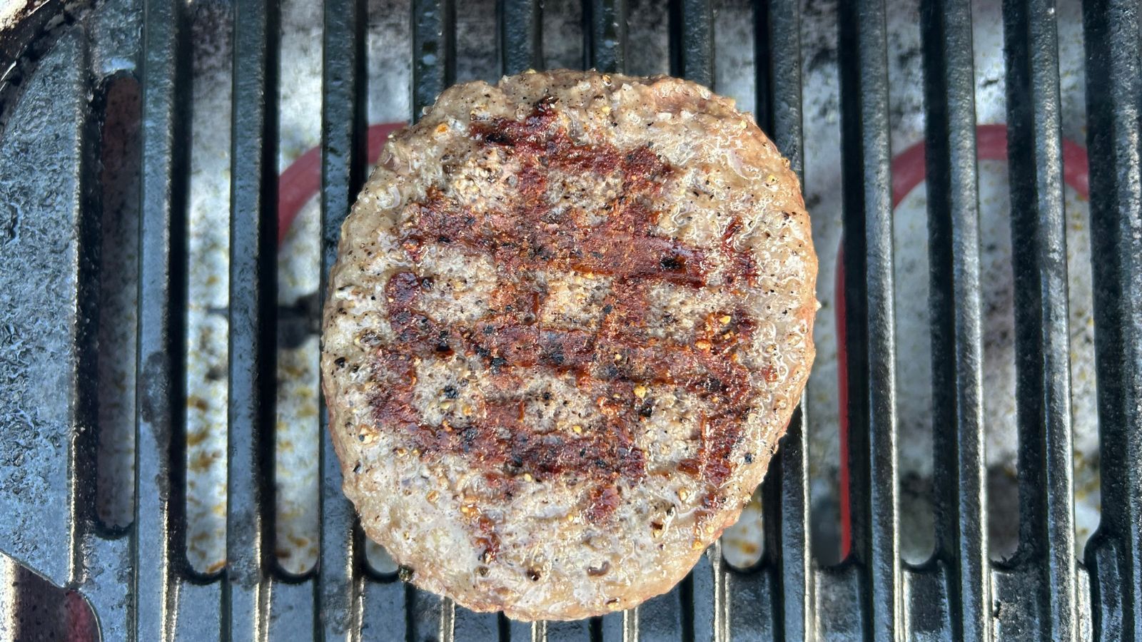 Electric BBQ cooking burger, finished, with criss-cross grill lines