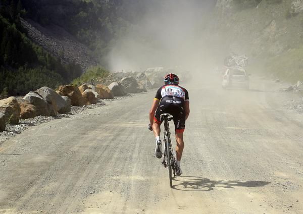 A Radioshack Nissan racer climbs a dirt road