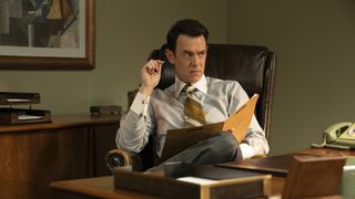 Colin Hanks sits at a desk in The Offer