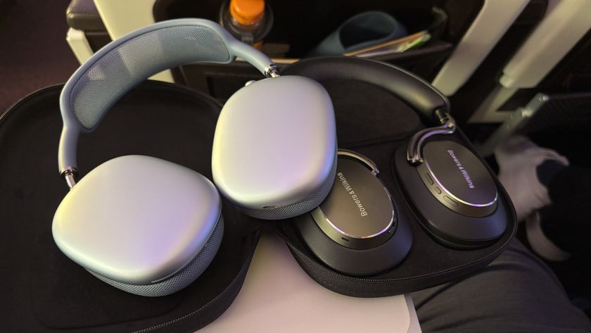 AirPods Max sat on B&amp;W PX8 S2 headphones on an aeroplane tray