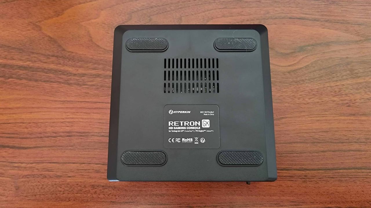 Hyperkin Retron GX with bottom facing upwards on woodgrain desk.