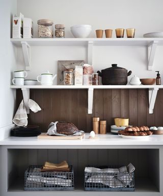 open shelve with splashback teapots and white teacup
