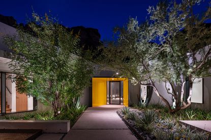 An outdoor pathway lighting up a front door