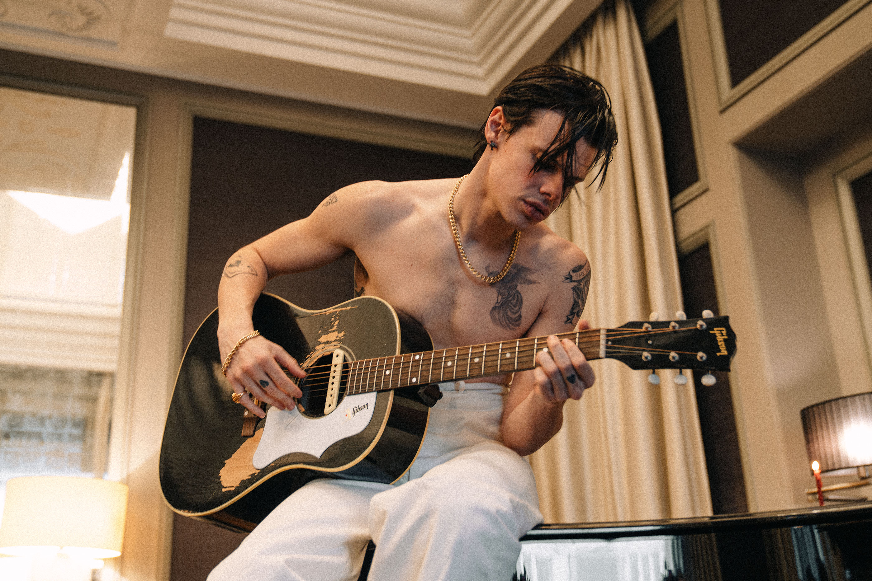 Yungblud plays an acoustic guitar