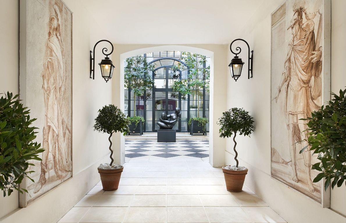 A series of modernly decorated rooms and exterior spaces features organic shaded decor, impressive sculptures, and art.