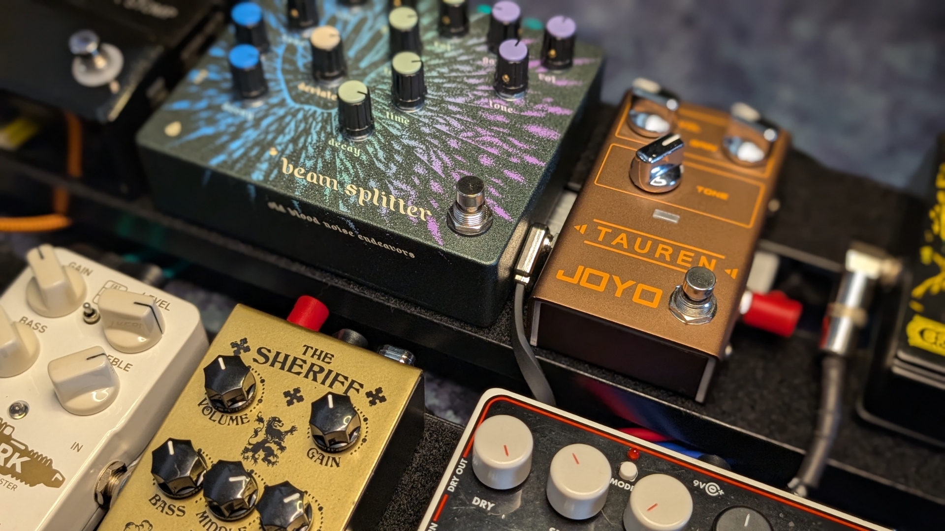 A selection of pedals on a pedalboard with patch cables