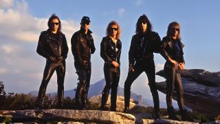 Judas Priest standing on rocky ground with a mountain behind them