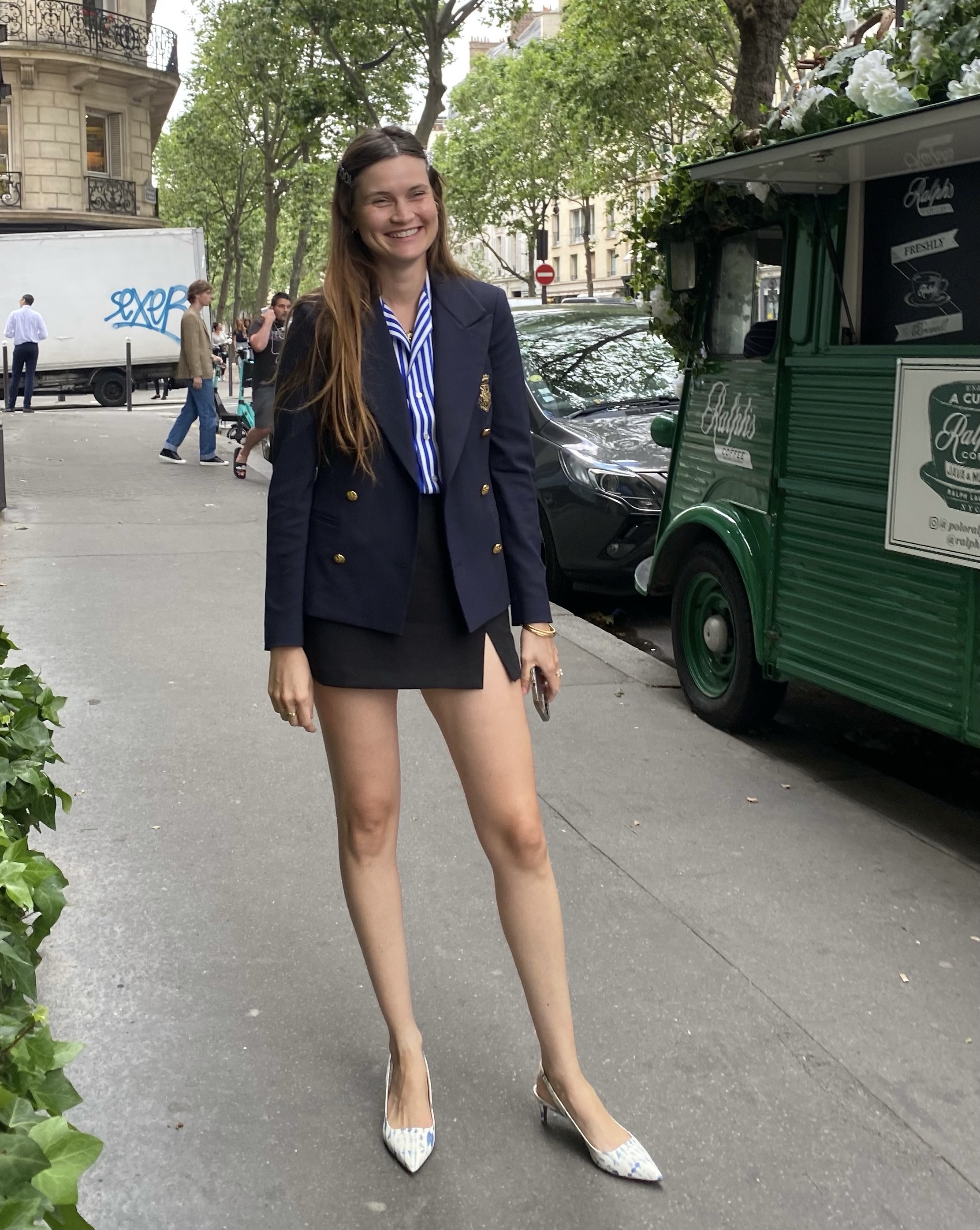 French writer and editor Eug&amp;eacute;nie Trochu poses in a nautical blazer, striped button-down shirt, a mini skirt and slingback heels