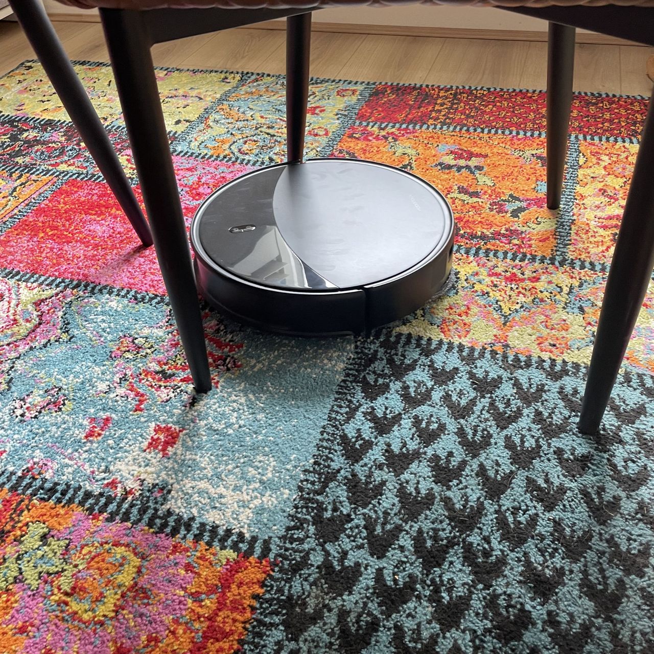 Roborock Saros 20 Robot Vacuum going through chair legs on a colourful rug