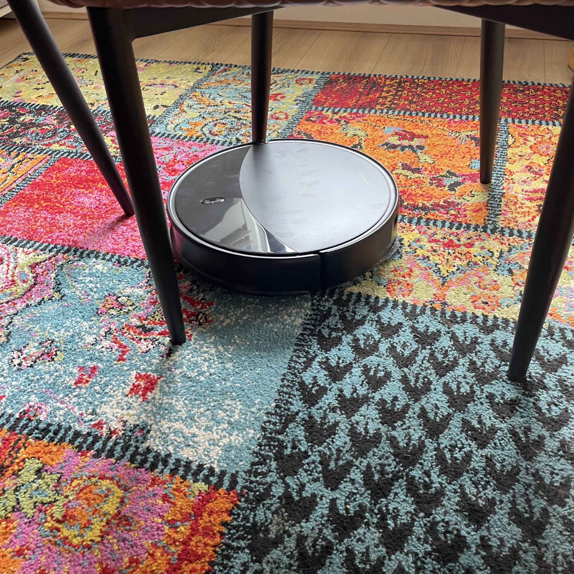 Roborock Saros 20 Robot Vacuum going through chair legs on a colourful rug