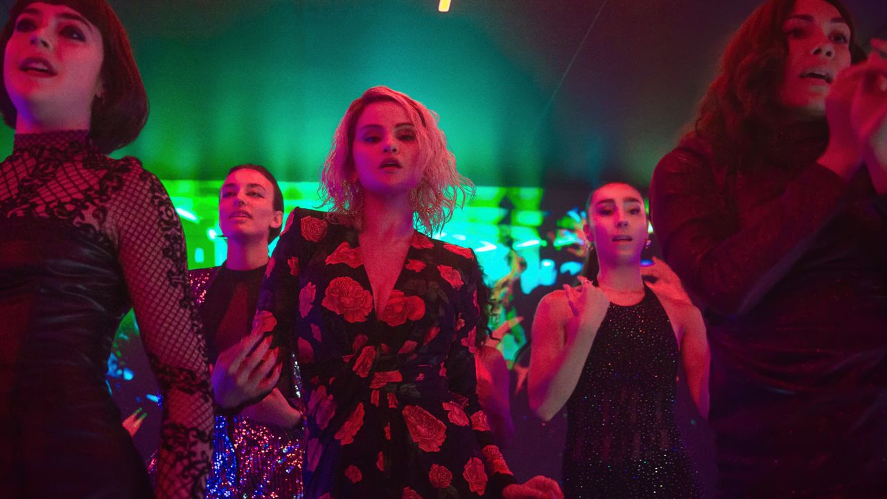 Selena Gomez dancing in a scene in Emilia Perez wearing a saint laurent floral suit with bleached blonde hair