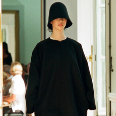 Model from The Row wears black wool bucket hat from Spring Summer 2024 collection.