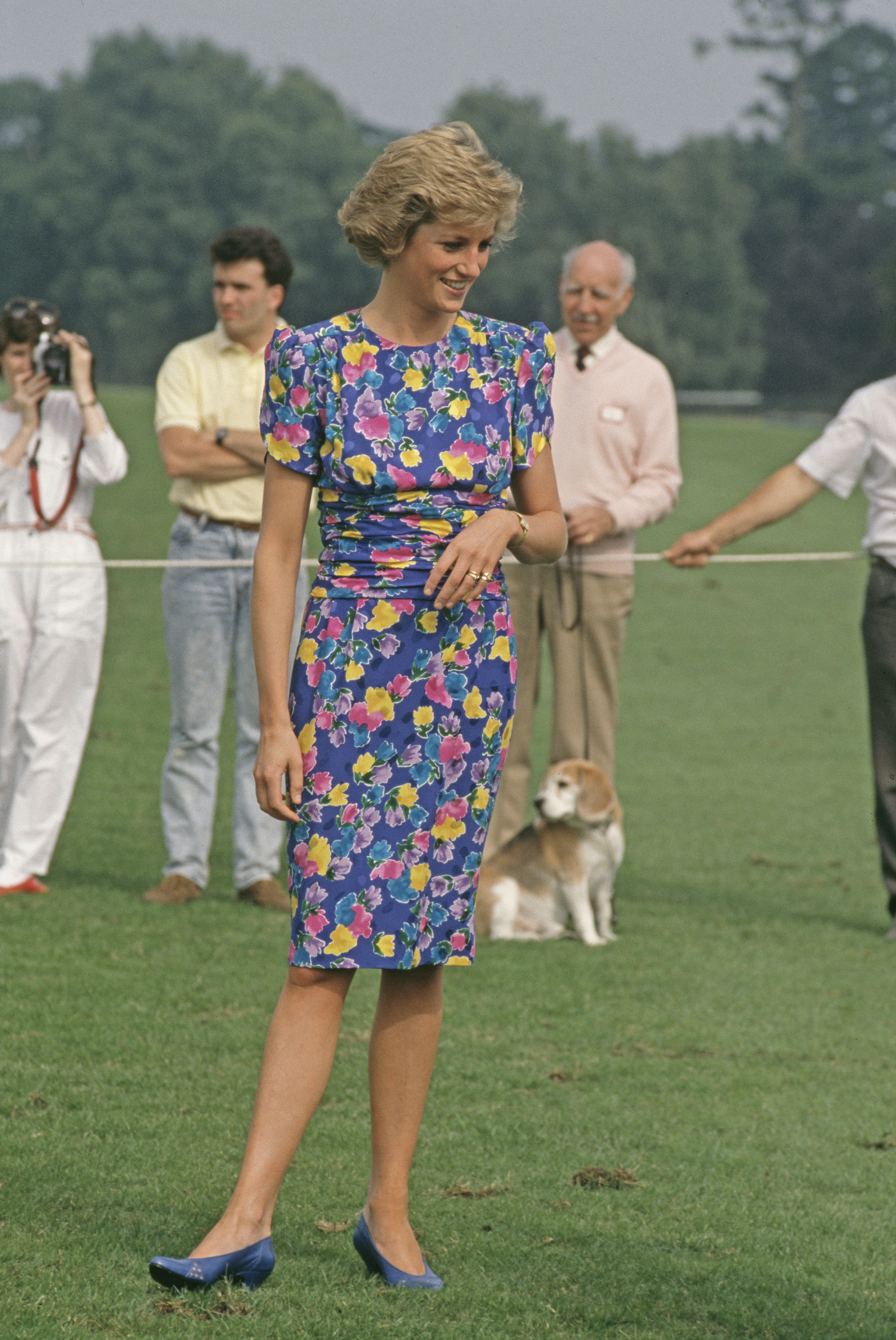Princess Diana wearing a blue floral dress standing in a field