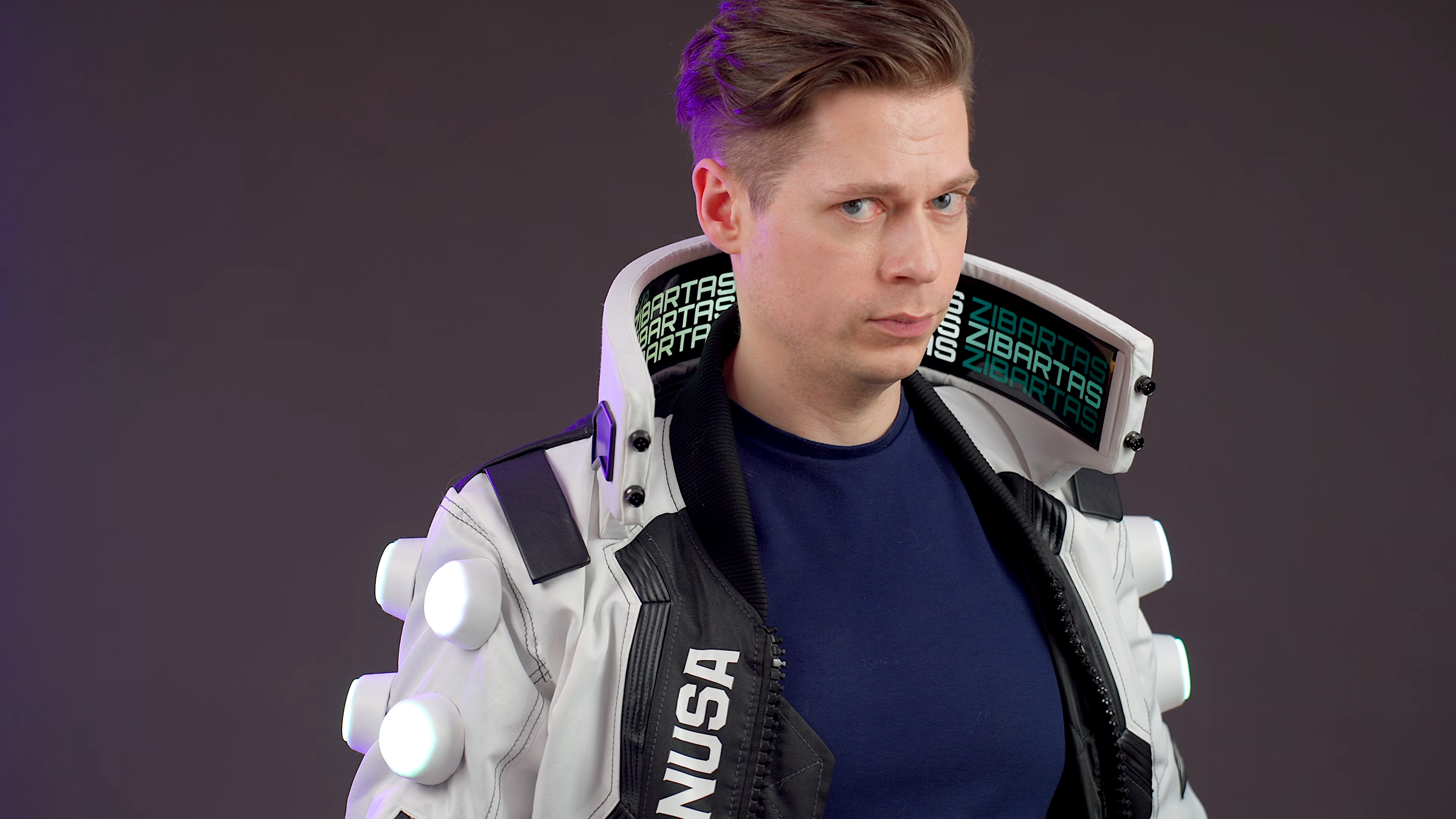 Cosplayer and hardware creator Zibartas models hand-made Cyberpunk 2077 bomber jacket. The garment features a tall standing collar with flexible OLED screens housed inside it.