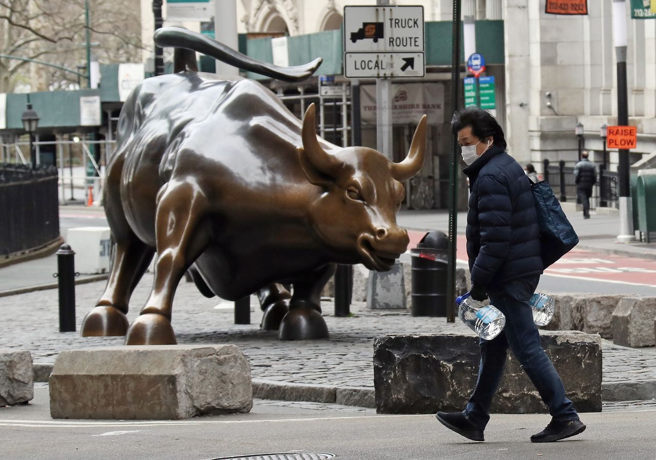 A pedestrian wearing a mask near Wall Street