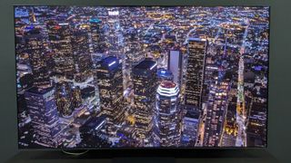 The Samsung S95D tv showing a picture of a city at night