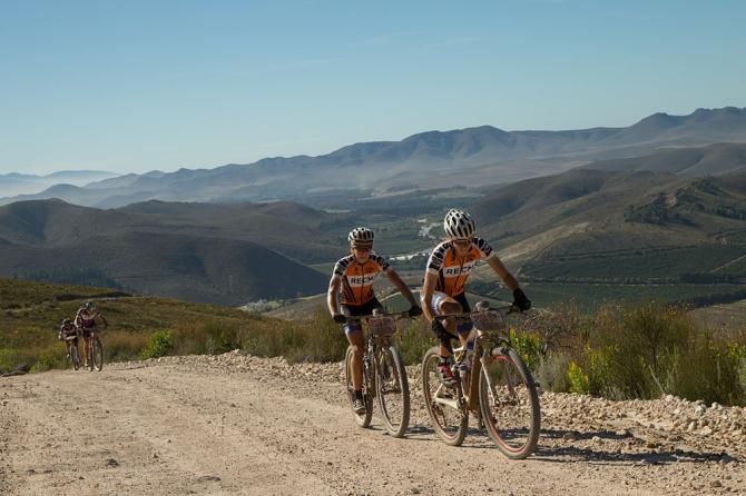 Ariane Kleinhans (front) and Annika Langvad of Team RECM2 pass the grandmasters leaders (Team Cycle Lab Toyota) during stage 5