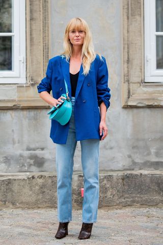 a woman wearing straight leg jeans with an electric blue blazer