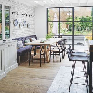 Open plan kitchen and dining area looking through glass doors to the garden beyond