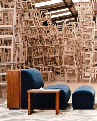 High stacks of wooden chairs with a comfy chair and table