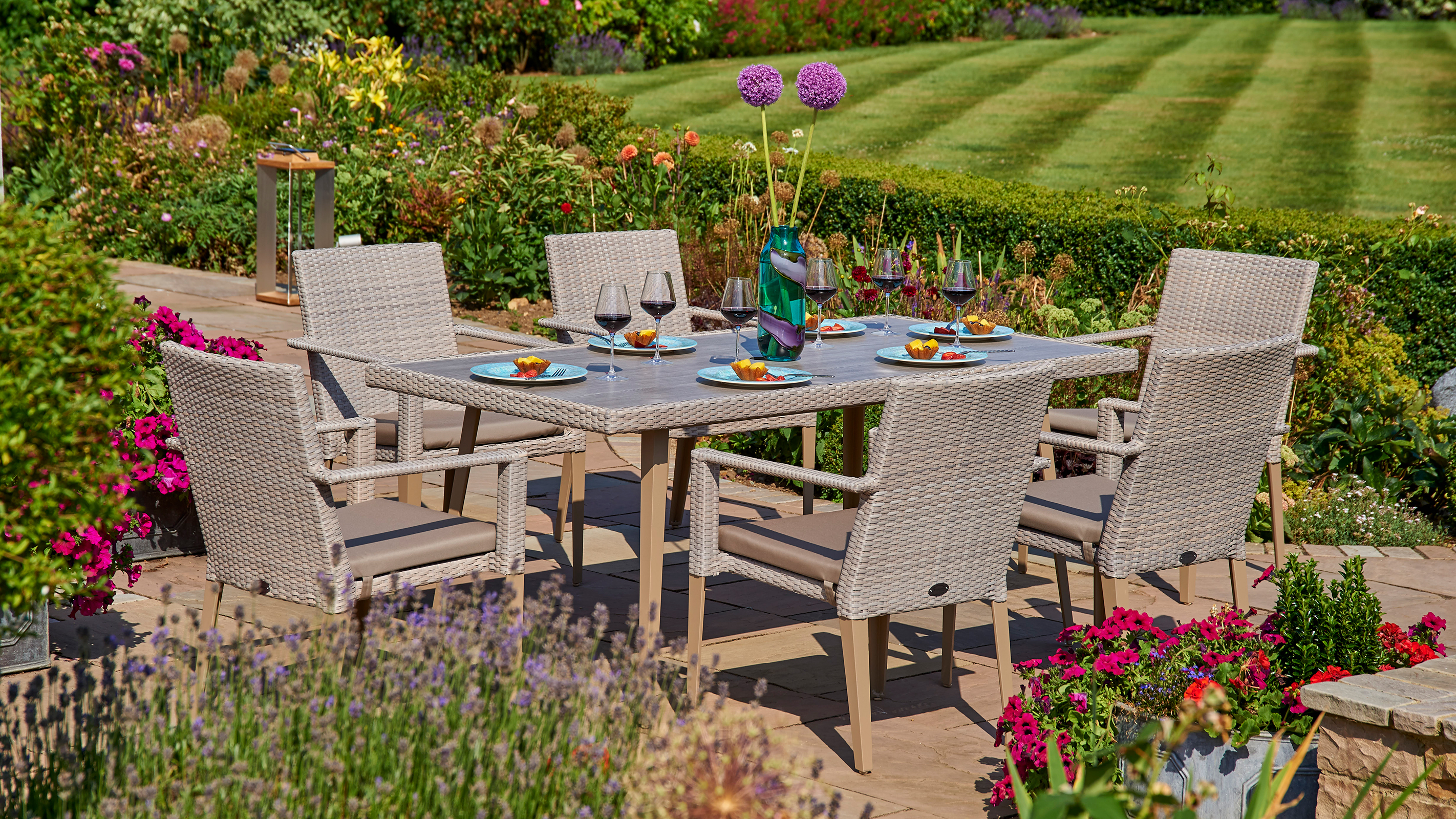 patio with wooden patio furniture and country garden planting