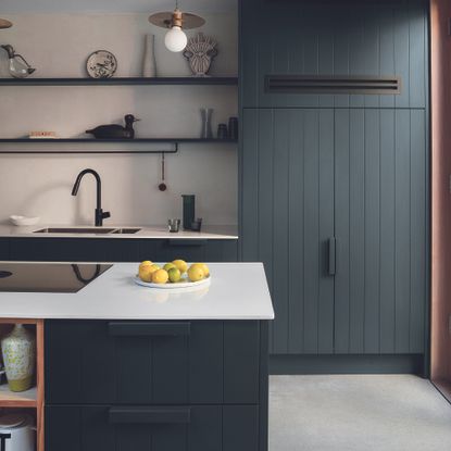 Black kitchen with island with white worktops