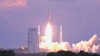 a rocket launch into a early morning sky colored pink and purple. 