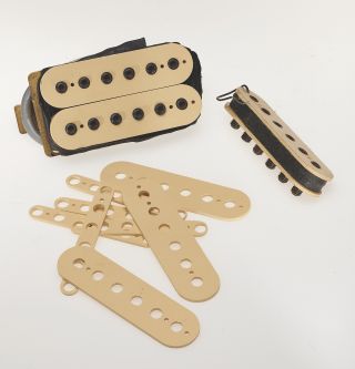 a pile of cream guitar pickup covers and pictured on a DiMarzio Super Distortion pickup