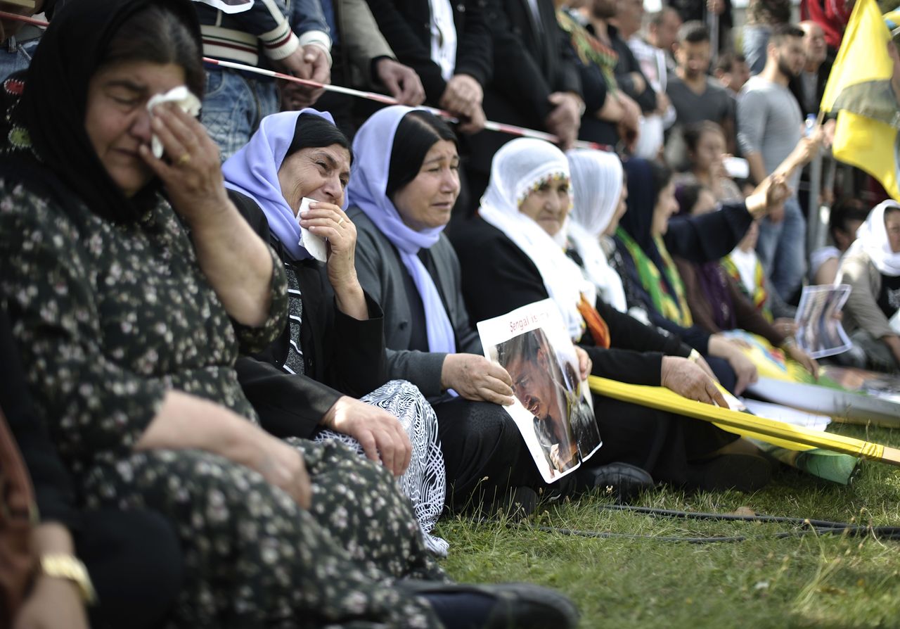 Yazidi women cry over lost loved ones.