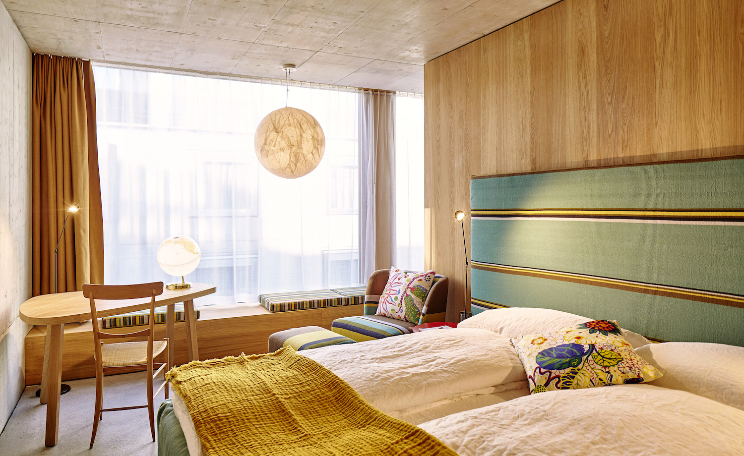 A hotel bedroom with table and window