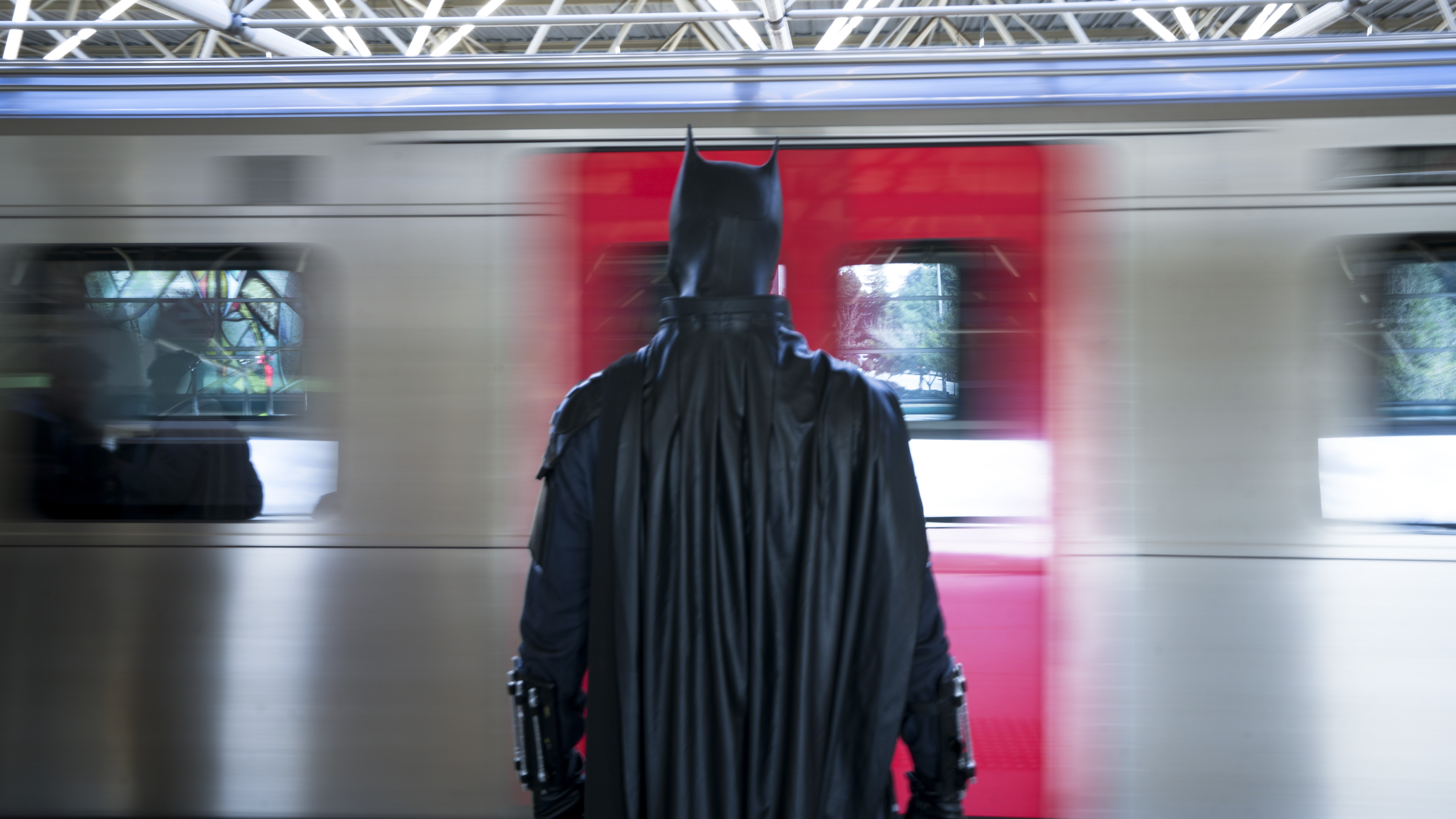 Batman waits outside a train