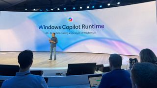A man on a stage talking about Windows Copilot Runtime