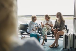 women sitting at airport and talking