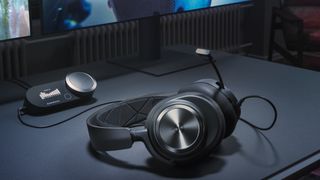 A SteelSeries headset resting on a desk before a PC screen