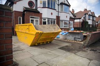 a skip in front of a house