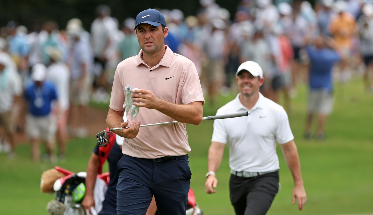 Scottie Scheffler and Rory McIlroy walk on to the putting green