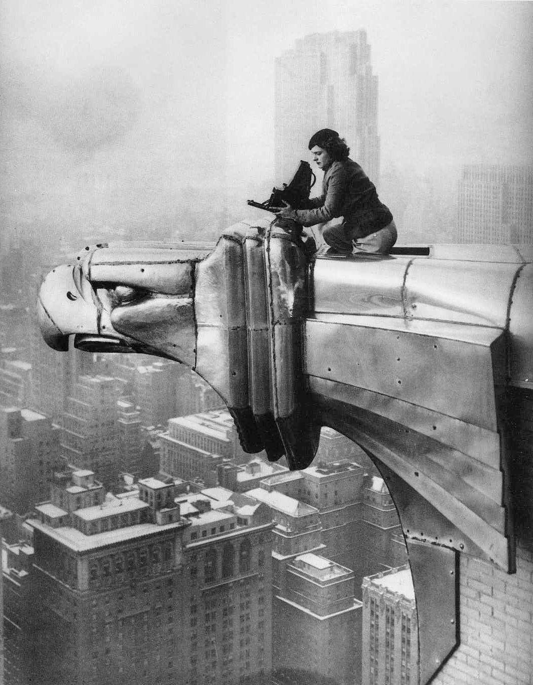A woman in the 1930s atop a skyscraper, perched on a large eagle-shaped sculpture, operates a camera