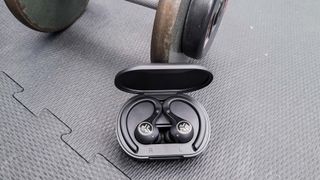 Hero image for best sport headphones showing JLab Epic Air Sport ANC 2 in the gym with a dumbbell weight in the background 