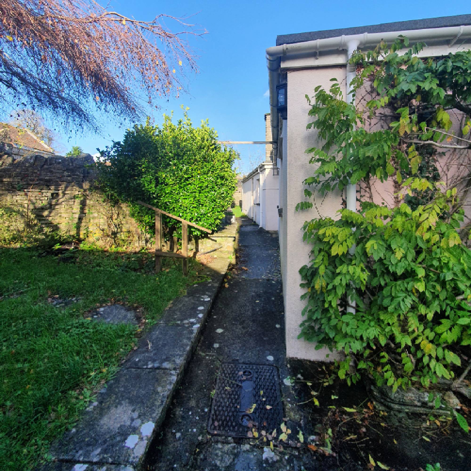 long narrow path behind cream house in the garden