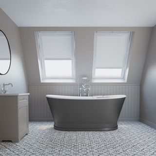 Grey bathroom with charcoal bathtub underneath two skylight windows