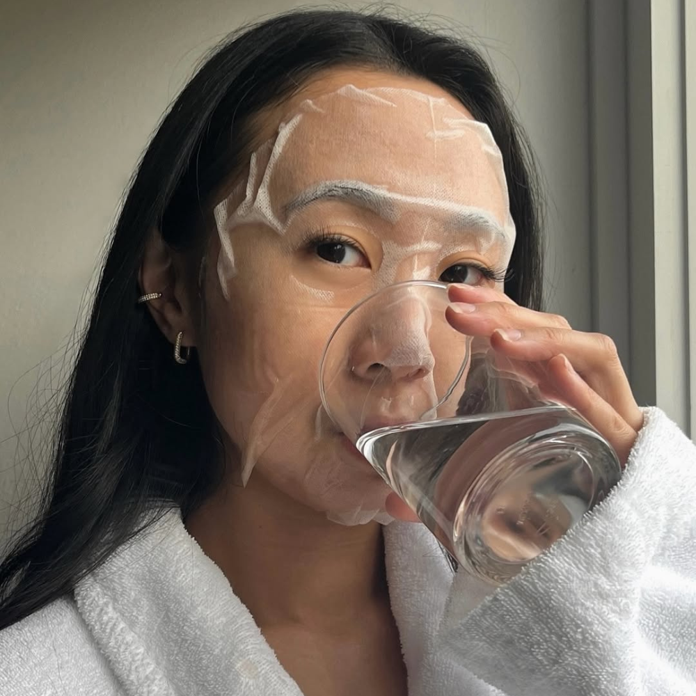 woman wearing a face mask drinking water