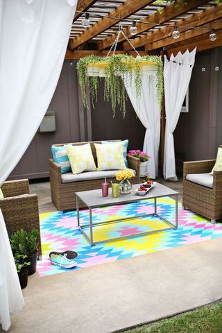 A colourful outdoor rug painted onto a patio with an aztec inspired design