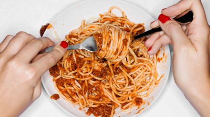 Stress eating: A woman eating a bowl of pasta