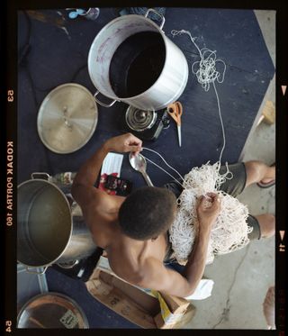 Jonathan preparing yarn to go into hibiscus dye dat Material Institute