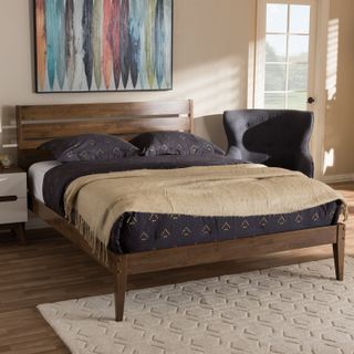 Midcentury Modern Wood Platform Bed with accent chair and dark bedding