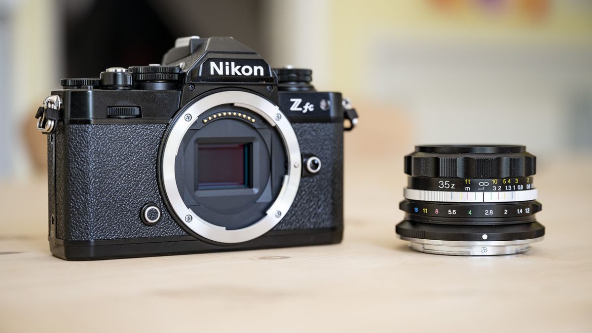 Voigtlander D 35mm f1.2 Nokton lens on a wooden table alongside a Nikon Z fc