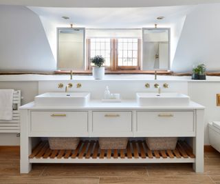 low window in bathrom with double vanity unit in front and mirrors mounted on windowshelf