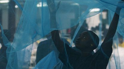 A worker inspects a mosquito net in Arusha, Tanzania