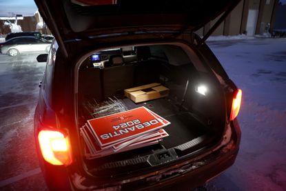 Ron DeSantis yard signs stacked in an SUV trunk